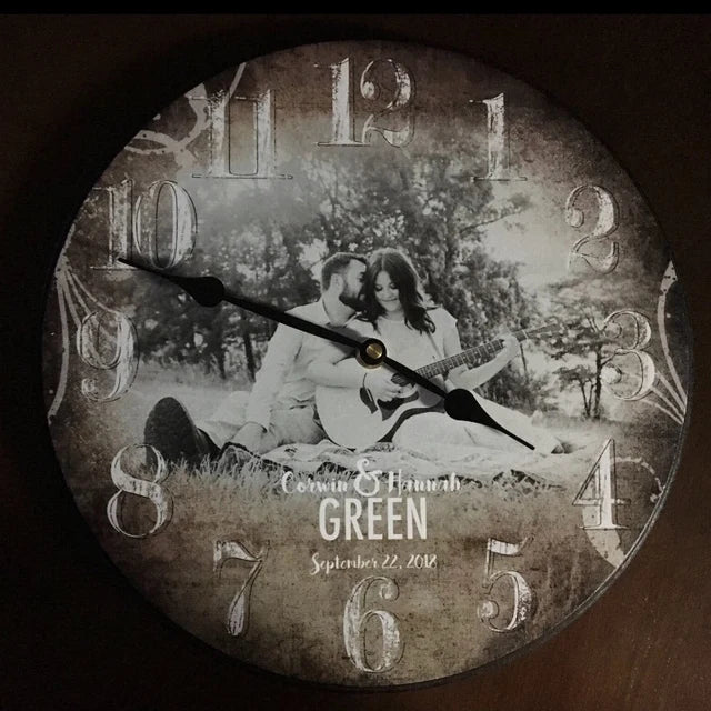 Customer-submitted photograph of the finished black-and-white clock featuring a couple with a guitar.