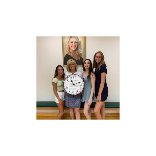 Four women holding a personalized keepsake clock together
